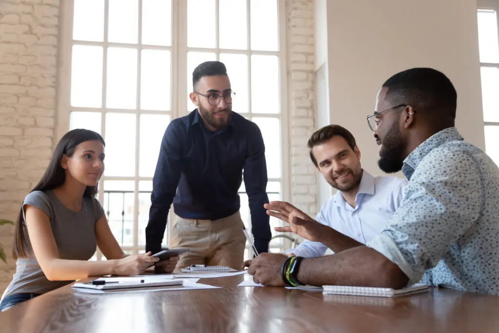 Four people talking at a meeting table