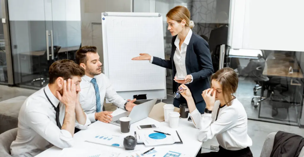 Angespannte Besprechung mit vier Personen vor einem Flipchart