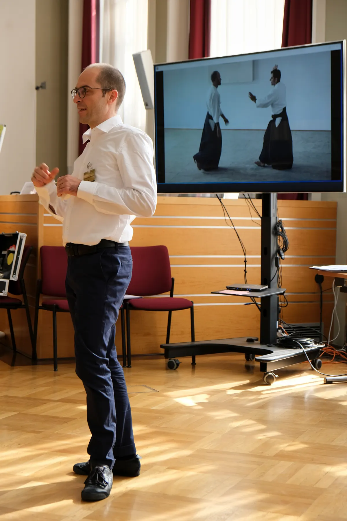 Christian von Baumbach bei einem Vortrag über Mediation, auf dem Bildschirm eine Aikido-Übung